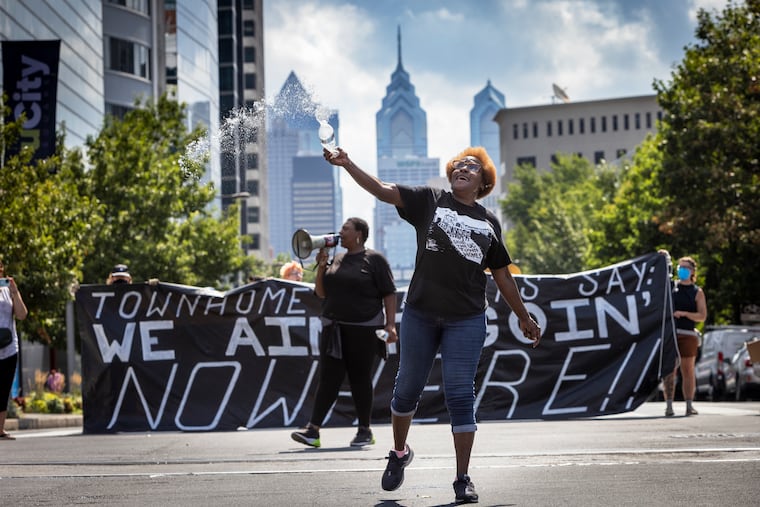 Darlene Foreman a representative with the Tenant Resident Council, throws water into air during a protest at 38th and Market Street where they shut down the intersection Monday.