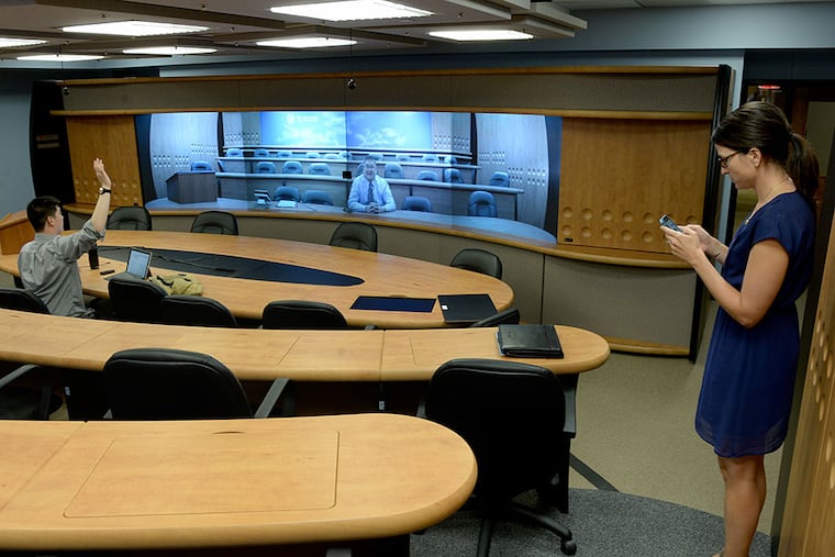 Ronald Chen, Rutgers Law co-dean, is projected on a large screen in what's been dubbed the "holodeck," connecting the Camden and Newark campuses to create one large classroom. TOM GRALISH / Staff Photographer