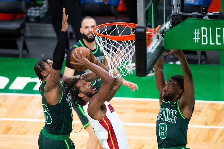 The Miami Heat's Trevor Ariza takes the ball to the basket against the Boston Celtics' Marcus Smart (36) and Kemba Walker (8) on Tuesday.