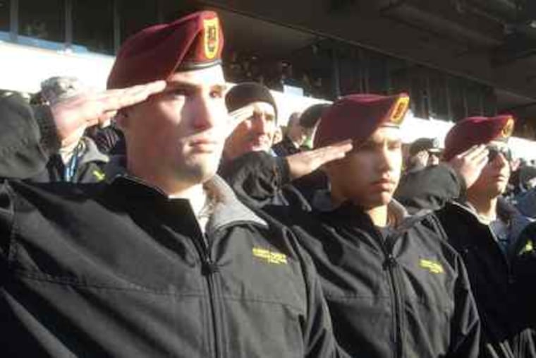 Salutes from soldiers wounded in Afghanistan: Pfc. James Beyer (left), Pvt. Matt Katka (center), and Pvt. Sean Beaver during the national anthem at the Linc before the Army-Navy game. "We remember you every day," said Adm. Mike Mullen, chairman of the Joint Chiefs.