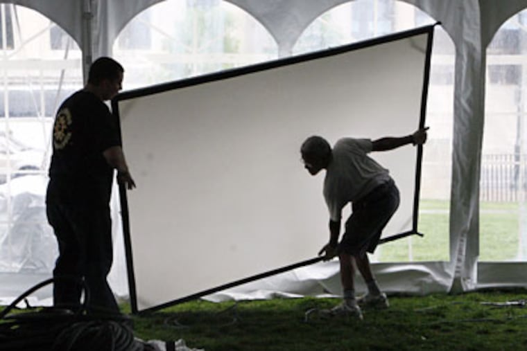 Jim Roach (left) and Keith Harewood move a video screen Friday in preperation for the Moore College of Art and Design Fashion Show on Saturday. (Elizabeth Robertson/ Staff Photographer)