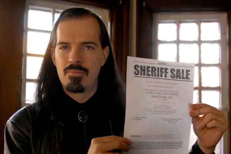 Patrick Rogers poses with "Sheriff Sale" document inside his home Feb. 11, 2011. ( Tom Gralish / Staff Photographer )