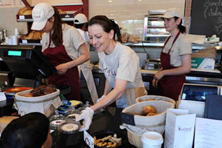 At Perrier’s Art of Bread, assistant manager Estelle Barberet hands an apricot petit delice to Matai Mistry, 2. (Sharon Gekoski-Kimmel / Staff Photographer)