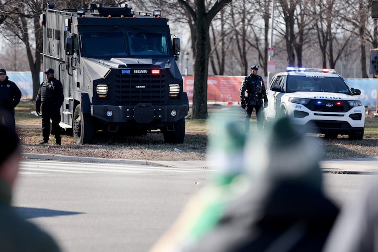 Eagles fans wait at a traffic light as an armored SWAT vehicle sits near the intersection of Broad Street and Pattison Avenue in Philadelphia on Sunday before the game against the New York Giants.