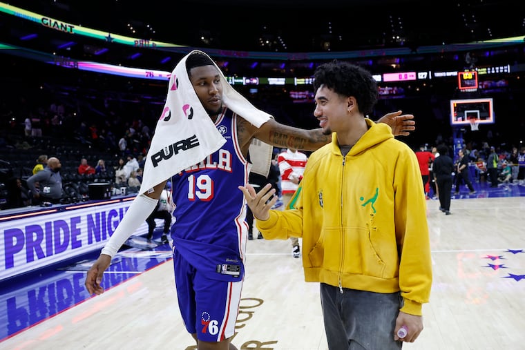 Sixers forward Justin Edwards (left) and injured teammate Jared McCain walk off the court after a game on March 30. McCain's promising rookie season was cut short by a knee injury and now he's recovering from thumb surgery.
