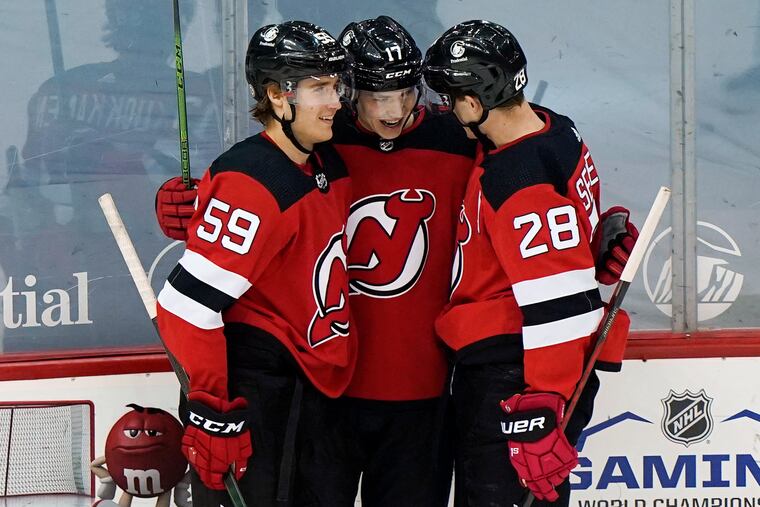 New Jersey Devils left winger Janne Kuokkanen (59) and defenseman Damon Severson (28) celebrate with center Yegor Sharangovich (17) after Sharangovich scored his second goal during the first period Thursday night against the Flyers. The Devils won, 5-3, knocking the Flyers out of the playoff race in the process.