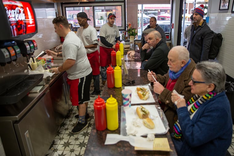 Jon Vellios (center) is the now the "Fifth George" to run his family sandwich shop on Ninth Street. The shop was closed for renovations for nine months – a period of double losses for the Vellios family.