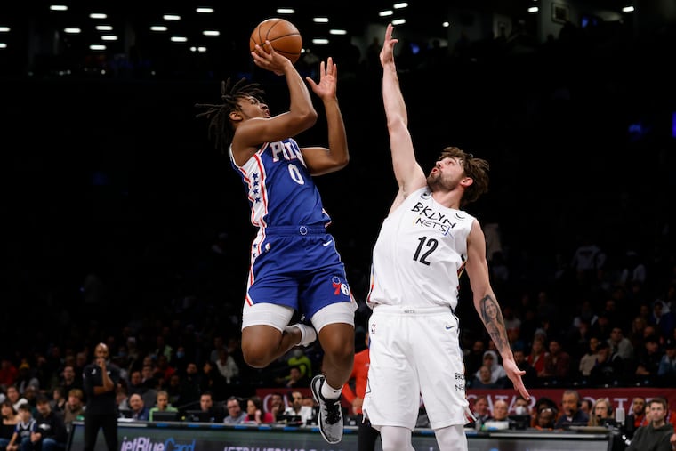 Tyrese Maxey (0) shoots as the Nets' Joe Harris defends during the first quarter. He finished with 12 points.