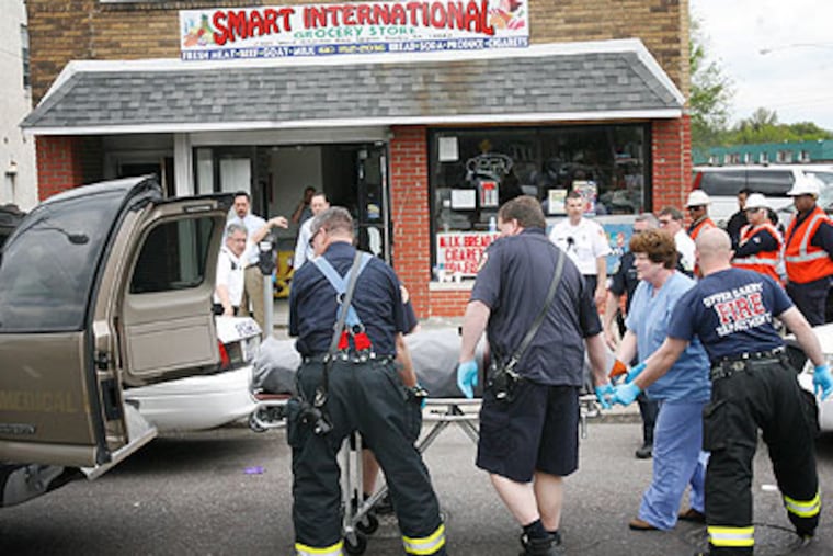 Upper Darby police load one of two bodies found in an apartment above Smart International Grocery, 7301 W. Chester Pike, Police said a generator was left running in the store and the fumes seeped up to the second floor apartment, killing the occupants. (Alejandro A. Alvarez / Staff Photographer)