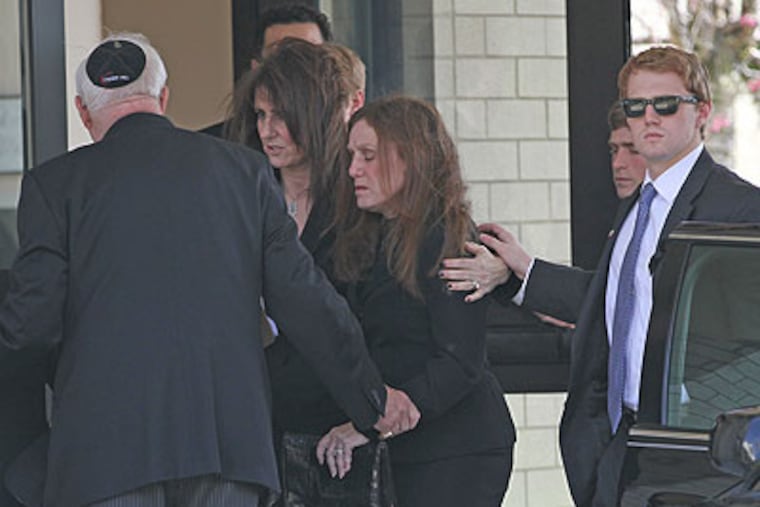 Former Congressman John Adler's widow, Shelley Adler, center, is comforted by her family and friends as she enters Temple Emanuel in Cherry Hill for her husband's funeral. (Michael Bryant / Staff Photographer)