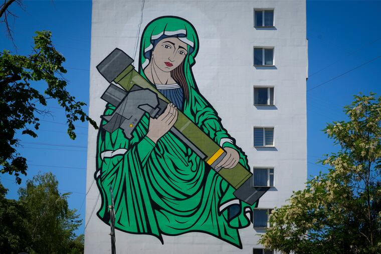A mural depicts an image known as "Saint Javelina" — the Virgin Mary cradling a U.S.-made FGM-148 anti-tank weapon Javelin — on a house wall in Kyiv, Ukraine.