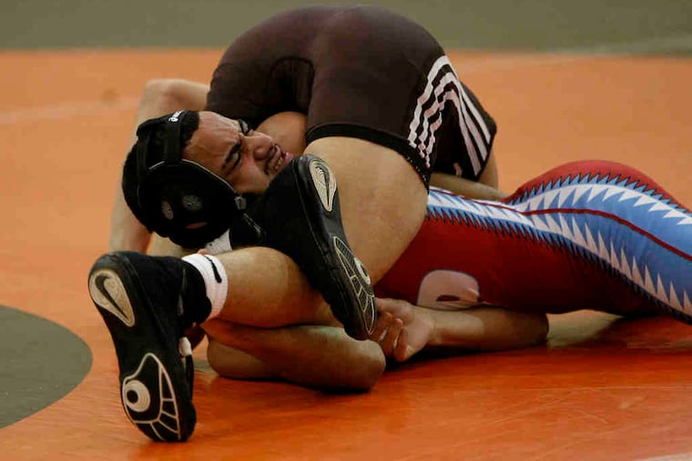 Pennsauken's Ricky Harkins grimaces as he is pinned by Cherokee's D.J. Mele in the 119-pound bout. Cherokee had six pins and two major decisions in nine wins en route to the 47-20 win.