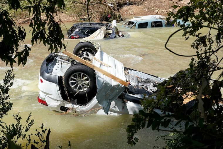 Vehicles come to rest in a stream on Sunday in Waverly, Tenn. Heavy rains caused flooding Saturday in Middle Tennessee and have resulted in at least 22 deaths.