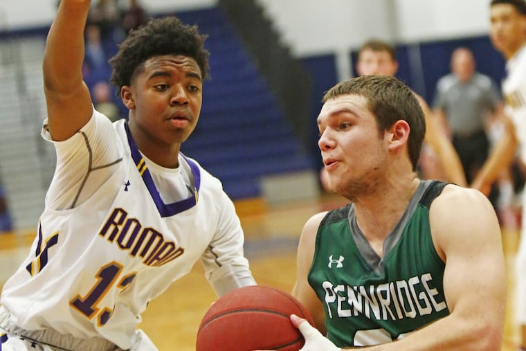 Roman Catholic’s Hakim Hart defends Pennridge’s Michael Molettiere during the Cahillites’ 58-56 win in Saturdays PIAA Class 6A playoff opener