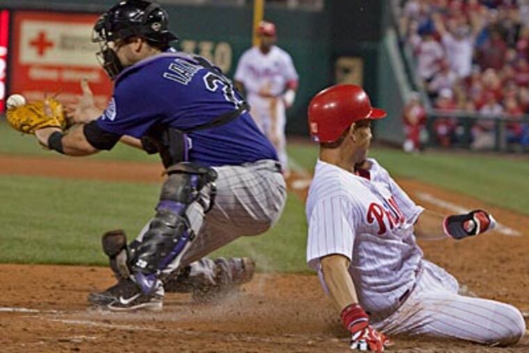 Wilson Valdez scores the winning run past Rockies catcher Chris Iannetta in the eighth inning. (Ed Hille/Staff Photographer)