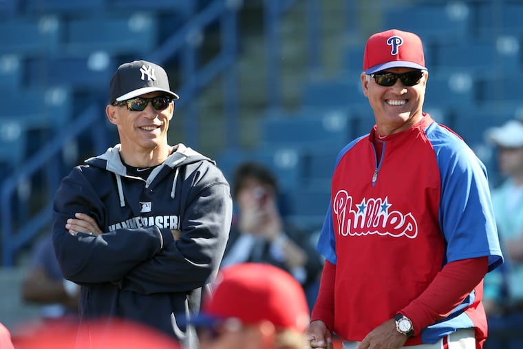 Then-Phillies Manager Ryne Sandberg laughs with then-Yankees Manager Joe Girardi.
