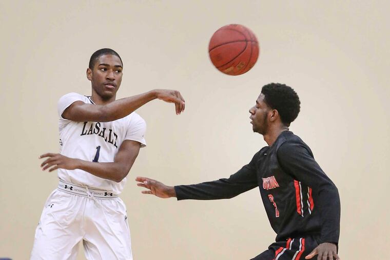 La Salle's Allen Powell throws a pass over Constitution's Hakim Hudson during the 1st quarter in Wyndmoor, Wednesday, December 13, 2017. STEVEN M. FALK / Staff Photographer