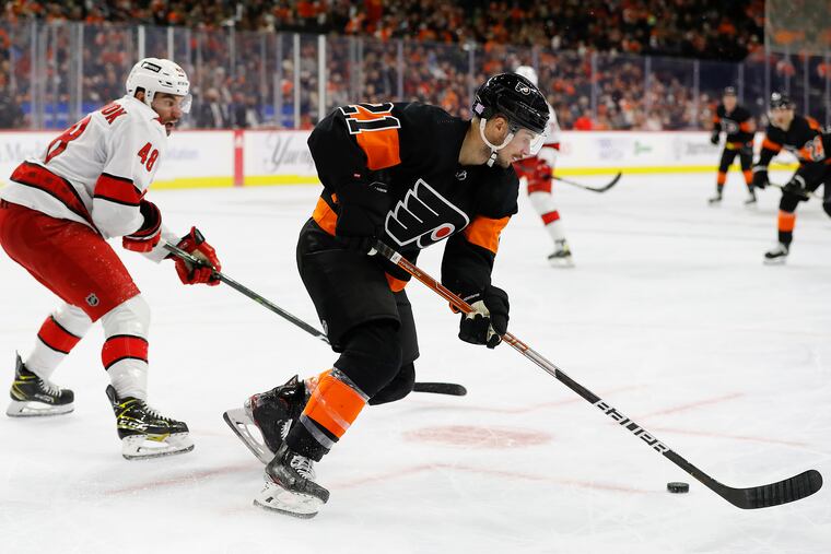 Flyers left wing Scott Laughton skates with the puck against Carolina Hurricanes left wing Jordan Martinook on Friday.