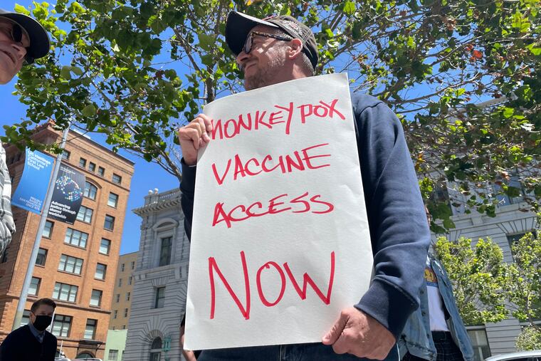 A man holds a sign urging increased access to the monkeypox vaccine during a protest in San Francisco on July 18.