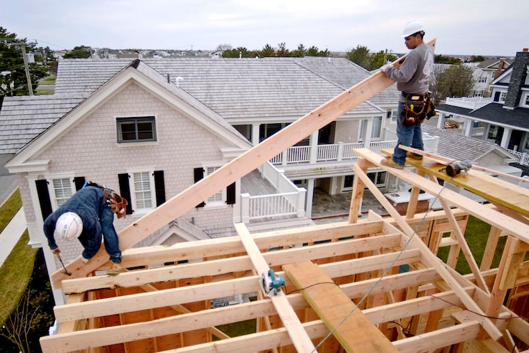 Workers help build a home in Stone Harbor. Construction workers are in short supply and competition is mounting among builders in 33 major markets as the number of new-home communities increases.