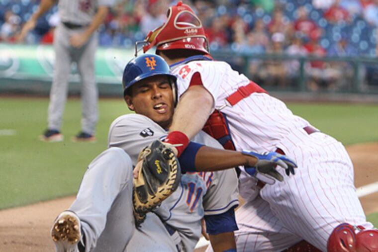 The Mets' Ruben Tejada is safe at home as Erik Kratz drops the ball during the first inning. (Ron Cortes/Staff Photographer)