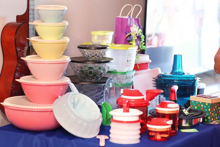 Tupperware items, including a set of "retro" storage containers at left, rest on a table during a Tupperware party in Sebastian, Fla., in 2022.
