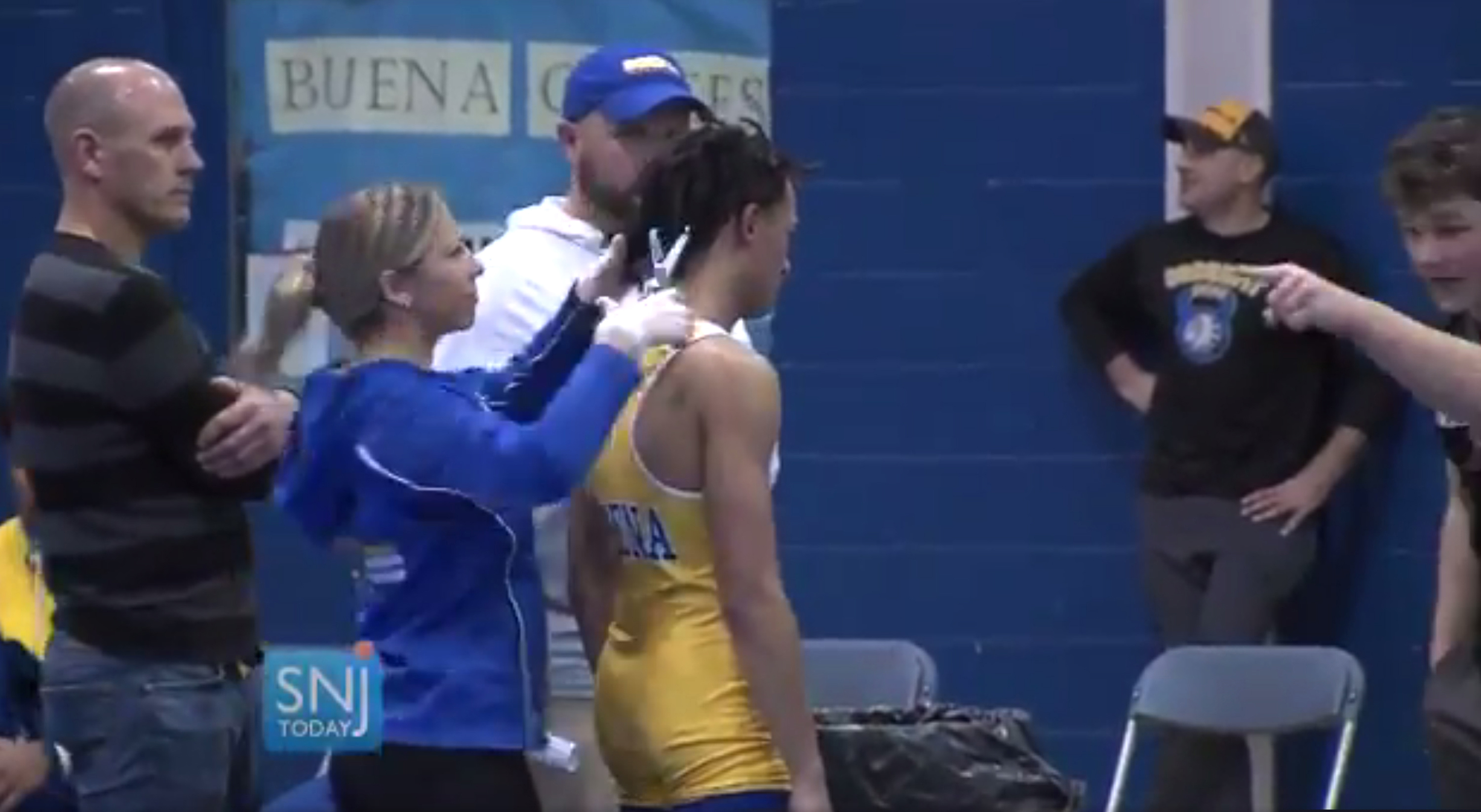 In this Dec. 19, 2018 image, Buena Regional High School wrestler Andrew Johnson gets his haircut courtside minutes before his match in Buena, N.J., after a referee told Johnson he would forfeit his bout if he didn't have his dreadlocks cut off.