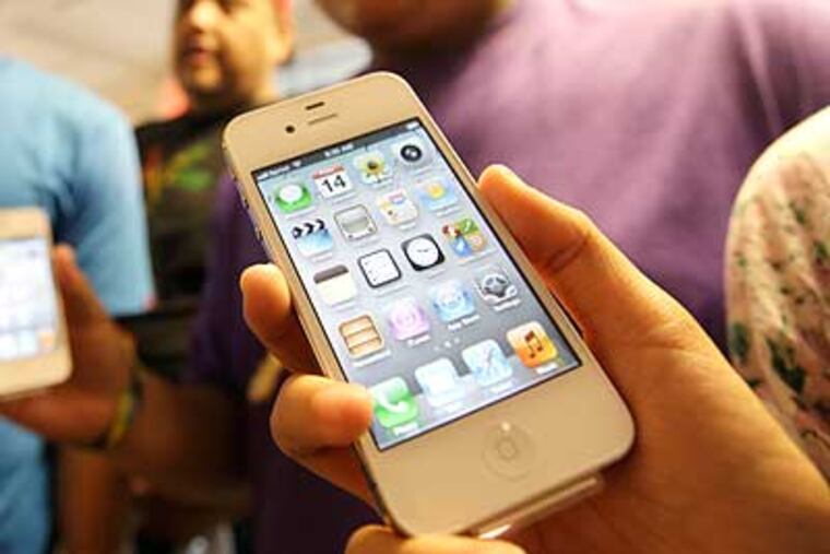 FILE - In this Oct. 14, 2011 file photo, the Leon Guerrero family, on vacation from Dallas, show off their new Apple iPhone 4S phones they purchased at a Sprint store in San Francisco. Apple said Monday, Oct. 17, 2011, it sold more than 4 million units of the new iPhone model in three days. It's selling more than twice as fast as the previous model did when it launched last year. (AP Photo/Eric Risberg, File)