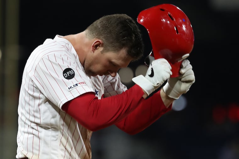 Rhys Hoskins of the Phillies slams his batting helmet on the turf after making the final out of the 8th inning against the Braves.
