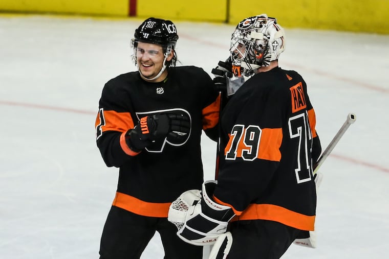The Flyers' Travis Konecny celebrates with goalie Carter Hart after beating the Penguins, 5-2, at the Wells Fargo Center on Jan. 15. Konecny had his first career hat trick in the victory.