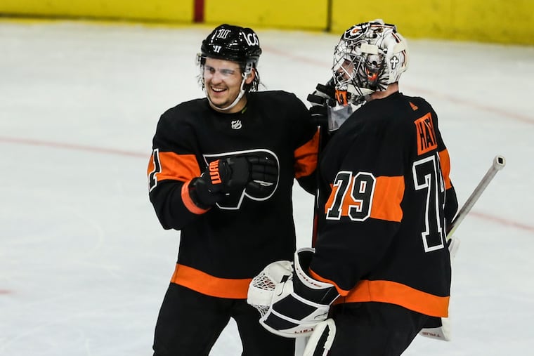 Flyers right winger Travis Konecny celebrates with goalie Carter Hart after beating the Pittsburgh Penguins, 5-2, at the Wells Fargo Center on Friday. Konecny had a hat trick and Hart was outstanding in the nets.