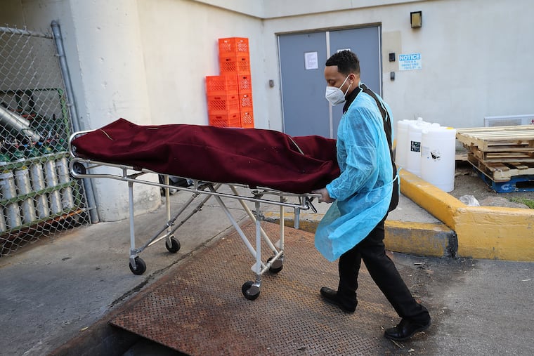 Preston Griffin of First Class Mortuary Transport wore protective gear as he removed a body from a Philadelphia-area nursing home on May 7.