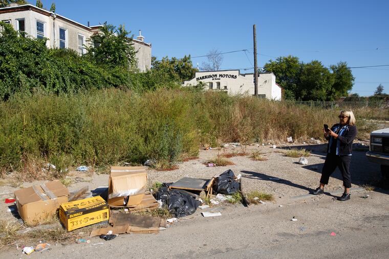 Clean block officer Diane Oliveras inspects the 2400 block of West Sedgely Street in North Philadelphia, as she conducts an indexing to determine where loose litter and illegal dumping is the worst, Tuesday, Oct. 3, 2017.