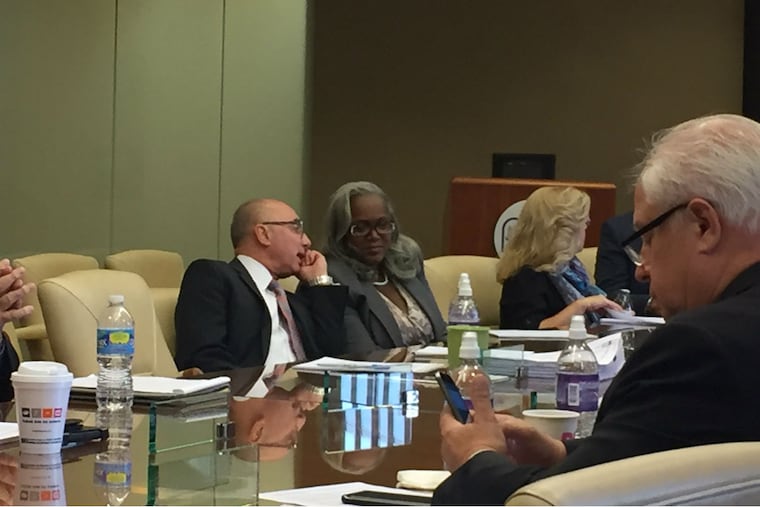 Clarena Tolson (second from left), the Parking Authority's new interim executive director, speaks to Richard Dickson (left), a first deputy executive director at the agency, during Thursday's board meeting.