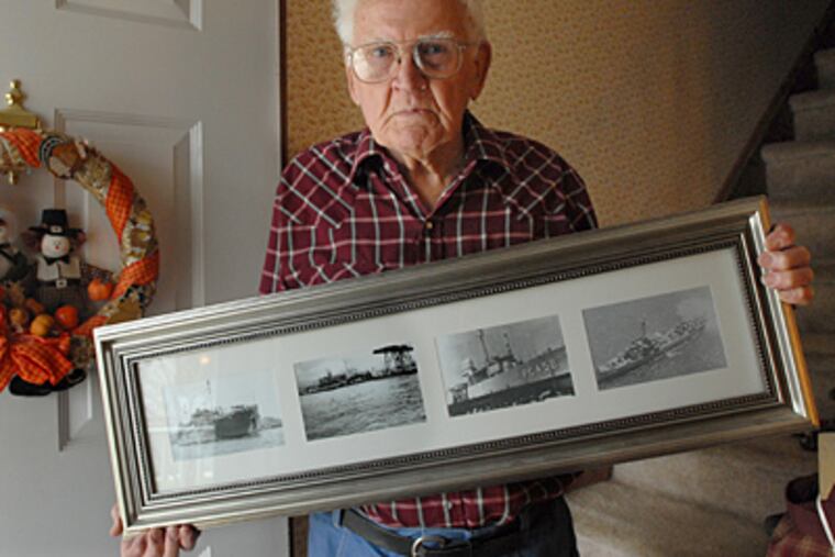 At his Burlington City, N.J. home, Pearl Harbor survivor Rowland Hoefle holds a framed group of photographs of ships on which he was stationed. ( April Saul / Staff Photographer )