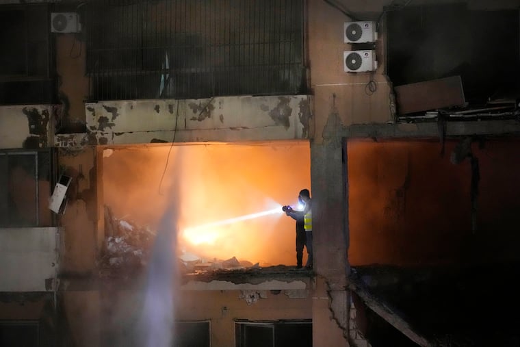 Civil defense workers search for survivors inside an apartment following a massive explosion in the southern suburb of Beirut, Lebanon, Tuesday, Jan. 2, 2024. The TV station of Lebanon's Hezbollah group says top Hamas official Saleh Arouri was killed Tuesday in an explosion in a southern Beirut suburb.