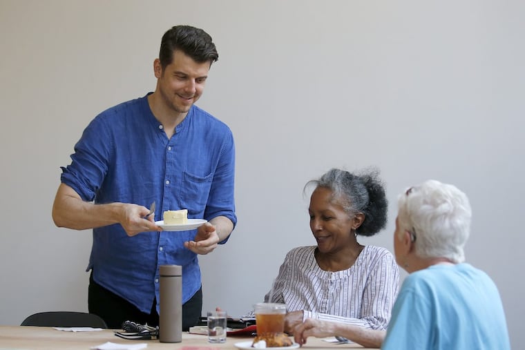 Co-founder of FRIEDA Thomas Steinborn (left) serves a slice of cake to Sharon Haymie (center) and Helen Grady before the the two ladies began their book club meeting on Thursday, May 18, 2017. YONG KIM / Staff Photographer