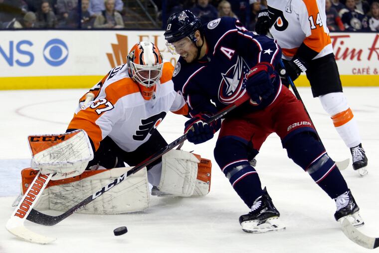 Flyers goalie Brian Elliott stops a shot in front of Blue Jackets forward Cam Atkinson during the second period.