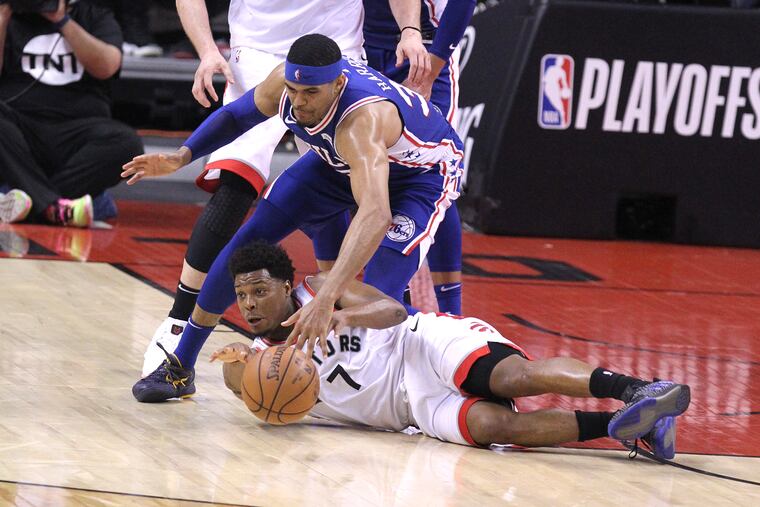 Kyle Lowry of the Raptors beats the Sixers' Tobias Harris to a loose ball.