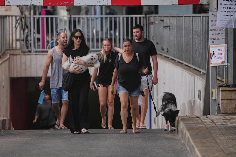 People leave an underground parking garage where they took shelter after an air raid alarm of Iranian missile attacks went off in Tel Aviv, Israel, on Tuesday, June 24, 2025.
