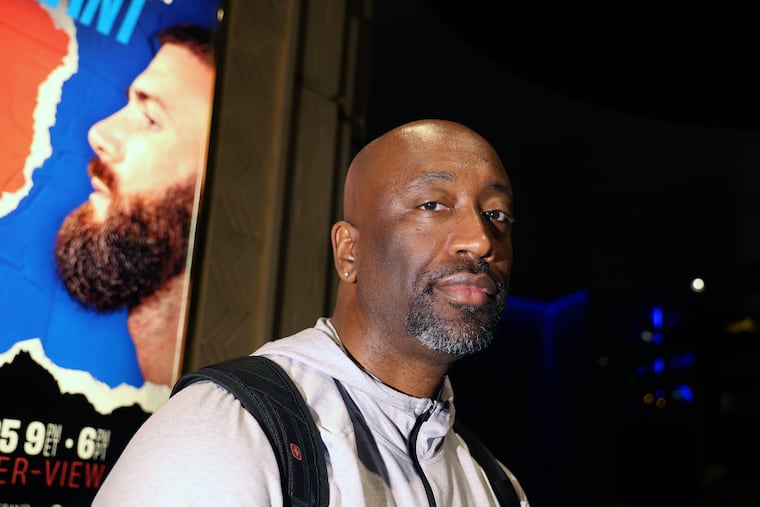 Boxing trainer Stephen Edwards stands near a poster for fighter Caleb Plant at MGM Grand hotel-casino in Las Vegas.