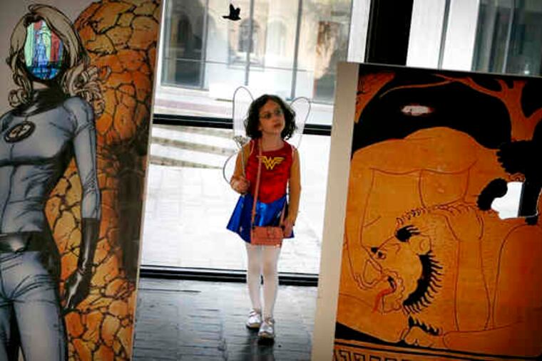 Josie Rossman, 6, of Philadelphia, dressed as Fairy Girl - her own creation - walks amid cutouts with spaces for visitors' faces.