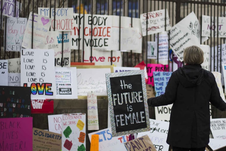 Lisa Mangiafico looks at signs that were left behind at the Philadelphia Women Rally January 21, 2017. Cities around the world hosted marches in support of women's rights after the inauguration of President Donald Trump, and Mayor Kenney said Philadelphia's March attracted 50,000 attendees.