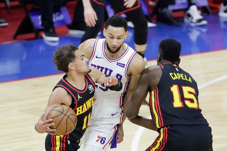 Hawks center Clint Capela (right) sets a screen for teammate Trae Young against Sixers guard Ben Simmons in Game 7.