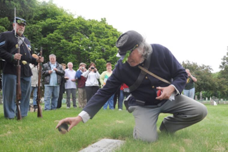 Civil War reenactors dedicate new tombstones for several brigade members of the 69th Pennsylvania Brigade. Here, Don Ernsberger and wife Louise Ernsberger wait for the brigade at the grave of Sgt. Dennis McGowan. (April Saul / Staff Photographer)