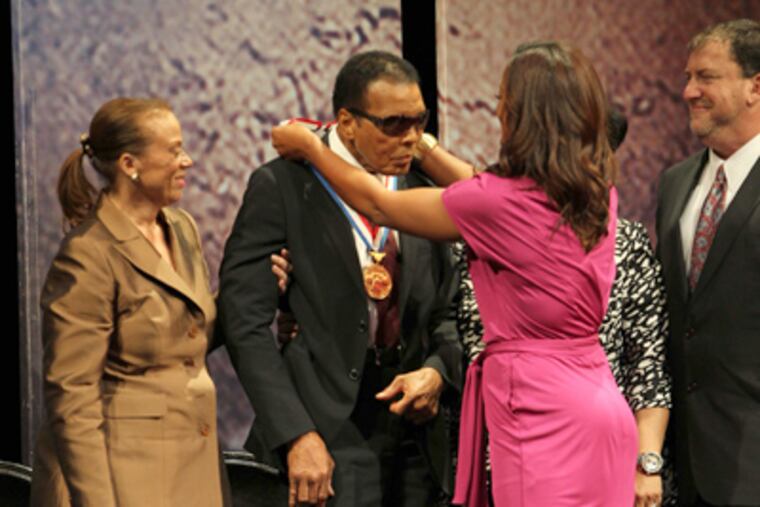 Muhammad Ali is presented the 2012 Liberty Medal by his daughter Laila Ali, with his wife, Yolanda, at left, on the lawn of the National Constitution Center. (David M Warren / Staff Photographer)