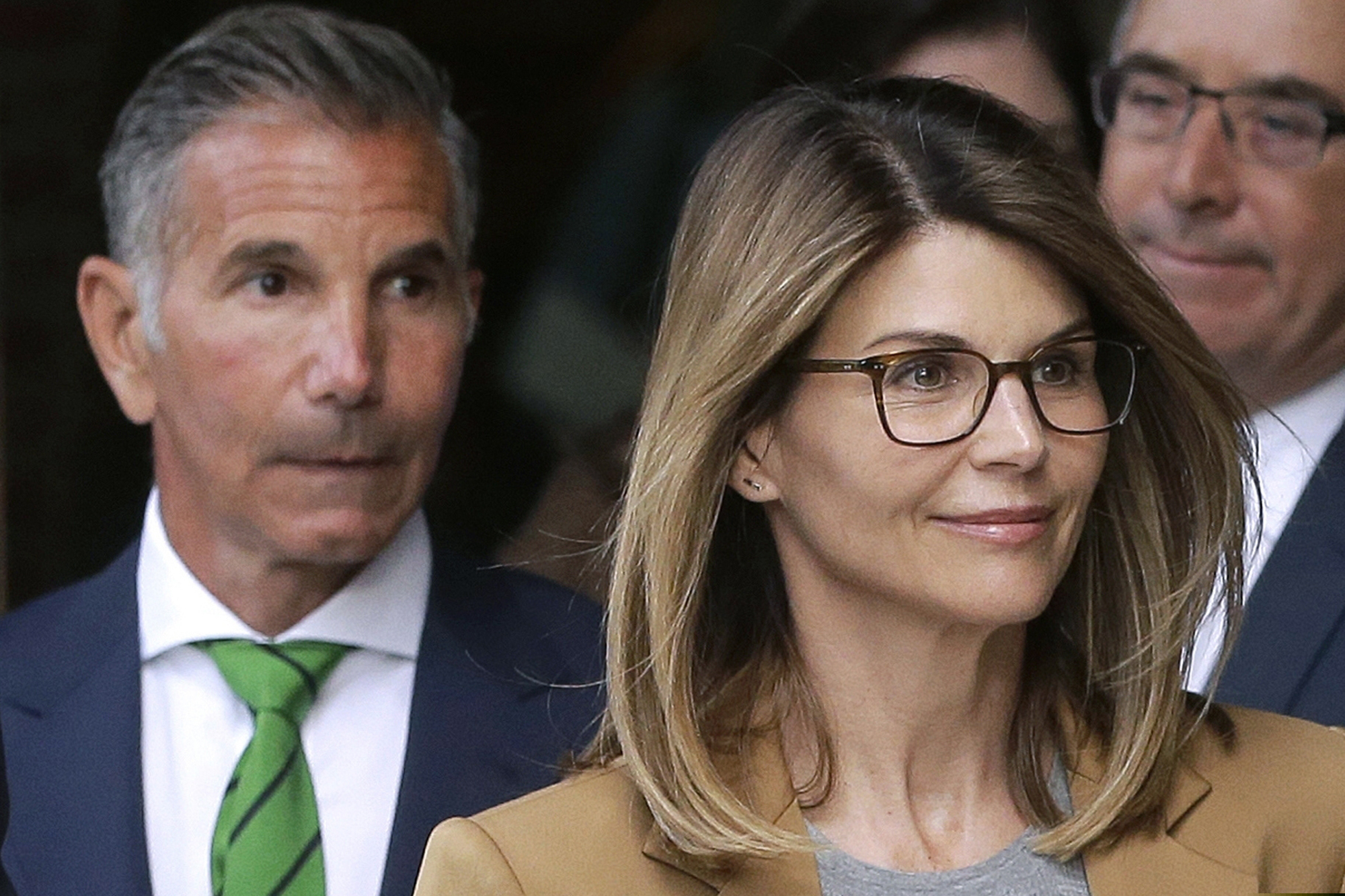 This April 2019 photo shows actress Lori Loughlin, front, and husband, clothing designer Mossimo Giannulli, left, departing federal court in Boston.