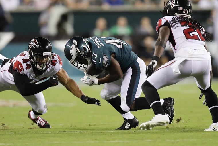 The Eagles' Darren Sproles running with the ball against Falcons defenders Vic Beasley (left) and defensive back Desmond Trufant last September.