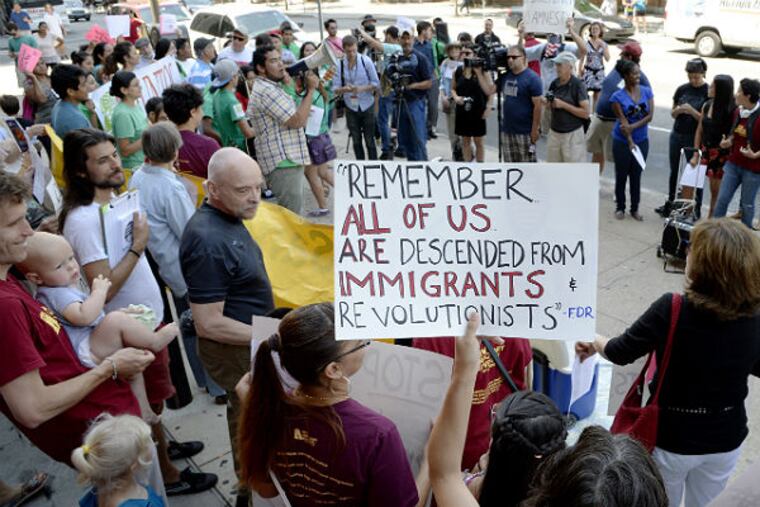 A group of about 100 pro-immigrant demonstrators gather views in a counter-protest against a group of Tea Party protesters Friday. The Tea Partiers were staging a rally against the surge in illegal immigration in front of The Bourse Building. (Clem Murray / Staff Photographer)