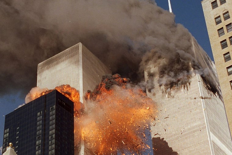 FILE- In this Sept. 11, 2001 file photo, smoke billows from World Trade Center Tower 1 and flames explode from Tower 2 as it is struck by American Airlines Flight 175, in New York.